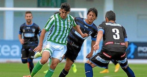 El verdiblanco Pibe lucha contra varios rivales durante el partido ante el Lucena.