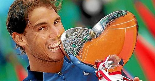 Rafa Nadal muerde su novena copa de campeón en Montecarlo. Rafa Nadal muerde su novena copa de campeón en Montecarlo.