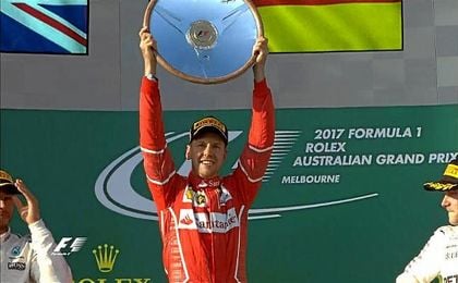 Sebastian Vettel levanta el trofeo de campeón del GP de Australia delante de Hamilton y Bottas. Sebastian Vettel levanta el trofeo de campeón del GP de Australia delante de Hamilton y Bottas.
