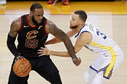 LeBron James lucha un balón con Stephen Curry. LeBron James lucha un balón con Stephen Curry.