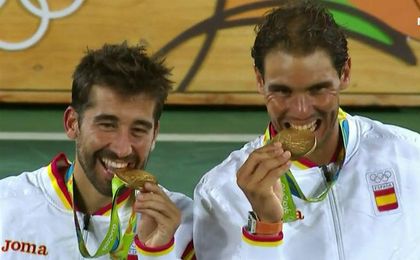 Rafa Nadal y Marc López muerden el oro conseguido. Rafa Nadal y Marc López muerden el oro conseguido.