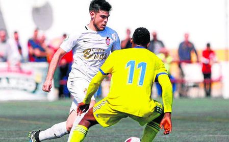 El futbolista utrerano Sergio Ortiz trata de marcharse del extremo cadista Peter. El futbolista utrerano Sergio Ortiz trata de marcharse del extremo cadista Peter.