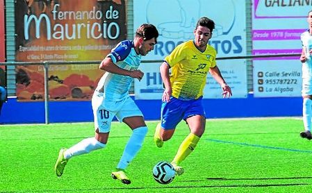 Guille, del Tomares, presiona a Jorge mientras conduce el esférico en una acción del partido. Guille, del Tomares, presiona a Jorge mientras conduce el esférico en una acción del partido.